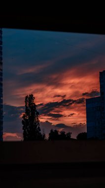 Harkiv 'de günbatımı. Şehir manzarası. Portakal Gökyüzü. Pencereden bak. Ağaç Silueti. Akşam bulutları. Ukrayna Şehri. Harkiv Binaları. Atmosferik Gökyüzü.