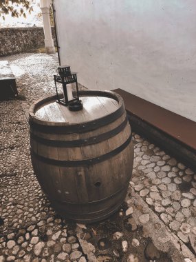 Eski Avrupa 'nın atmosferinde, duvarın yanında, eski bir duvarın üzerinde fener bulunan eski ahşap bir fıçı.