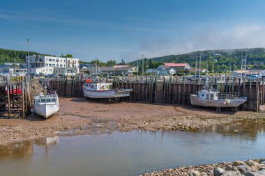 Bir grup tekne Alma Kanada 'da dalgaların çekildiği kayalarda oturuyor.
