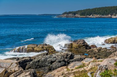 Dalgalar geliyor ve Bar Harbor Maine 'deki Acadia' da kayalık kıyılara çarpıyor.