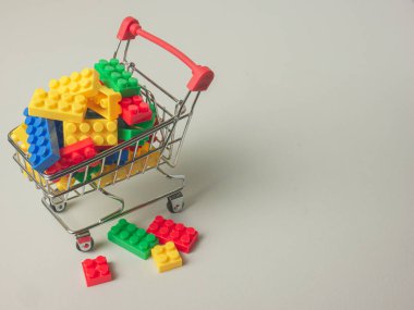 Çocuk ya da eğitim konsepti için süpermarket arabasında plastik yapboz kutusu. Çocuk konsepti fikri için bulmaca blick çok renkli