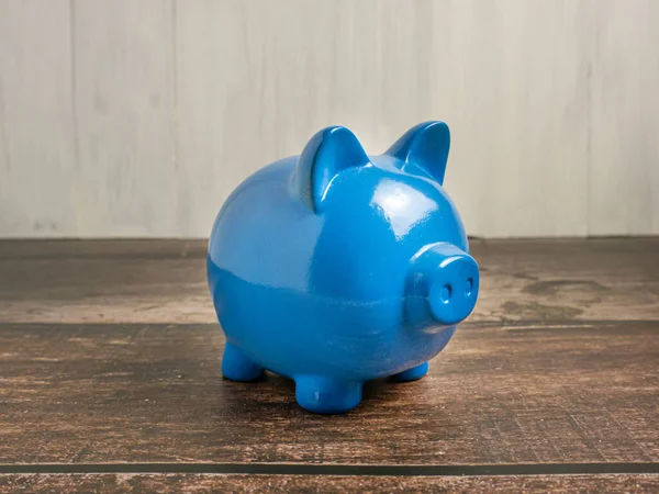 blue piggy bank on wood table for earn or saving concept