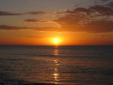 Sakin bir denizin üzerinde yükselen güneşin görüntüsü. Yaz gündoğumu.
