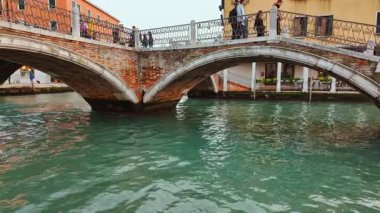 VENICE, İtalya, 5 Kasım 2024 - Venedik, İtalya 'daki ünlü kanallardan birinin çarpıcı görüntüsü, ilginç binalar, güçlü yansımalar ve canlı yeşil su