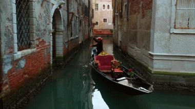 VENICE, İtalya, 5 Kasım 2024 - Venedik, İtalya 'daki ünlü kanallardan birinin çarpıcı görüntüsü, ilginç binalar, güçlü yansımalar ve canlı yeşil su