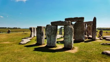 Iconic sarsen sütunları Stonehenge, Salisbury, Wiltshire, İngiltere 'de açık gökyüzünün altında çimenli düzlüklerde mükemmel bir daire şeklinde dizilmiştir.