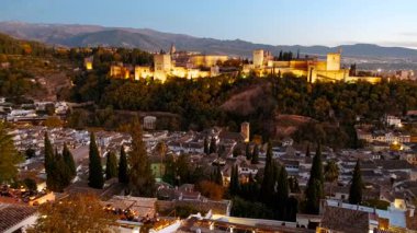 Granada, İspanya, 22 Kasım 2023 - Aydınlatılmış Alhambra Sarayı gece gökyüzüne, Granada 'ya, Endülüs' e, İspanya 'ya karşı parlayan karmaşık Fas kemerlerini ve kafes çalışmalarını sergiliyor