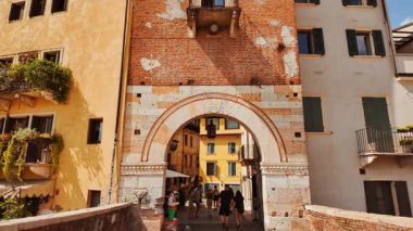 VERONA, İtalya, 12 Temmuz 2024 - İtalya, Verona, Veneto, İtalya 'da Ponte Pietra Roma Köprüsü' ndeki tepe manzaralı antik taştan tarihi bir köprü