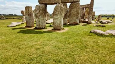 Yıpranmış megalitik taşlar Stonehenge, Salisbury, Wiltshire, İngiltere, İngiltere 'de rüzgarlı ovalarda dimdik durur.