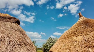 SALISBURY, İngiltere, 12 Mayıs 2025 - Stonehenge, Salisbury, Wiltshire, İngiltere, İngiltere 'deki tarih öncesi taşlara komşu ilkel kereste çerçeveli barakalar ve toprak tepecikleri