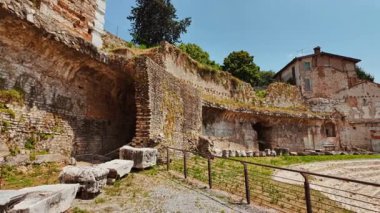 BRESCIA, İtalya, 20 Temmuz 2024 - Tempio Capitolino Roma Harabeleri, Brescia, Lombardy, İtalya 'nın modern caddelerinde nöbet tutan uzun kolonlar ve yıpranmış kireçtaşı bloklar