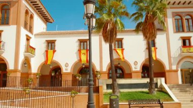 Palos de la Frontera 'daki Plaza de Espana, Huelva, Endülüs, İspanya, İspanyol bayraklarıyla süslenmiş, ulusal gurur ve tarih yayıyor.