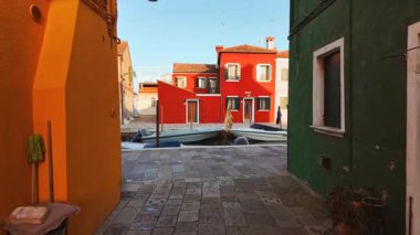 Venedik, İtalya, 7 Kasım 2024, Venedik, İtalya 'da renkli ve geleneksel evlerle dolu bir caddeyi ve bir kanalı gözler önüne sermek. Venedik 472 köprüsü olan 126 adadan oluşan bir takımadadır.