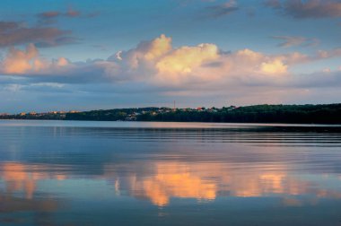 Akşam gökyüzünde güzel bulutlar Ternopil şehrinin manzarasında su yansıması.