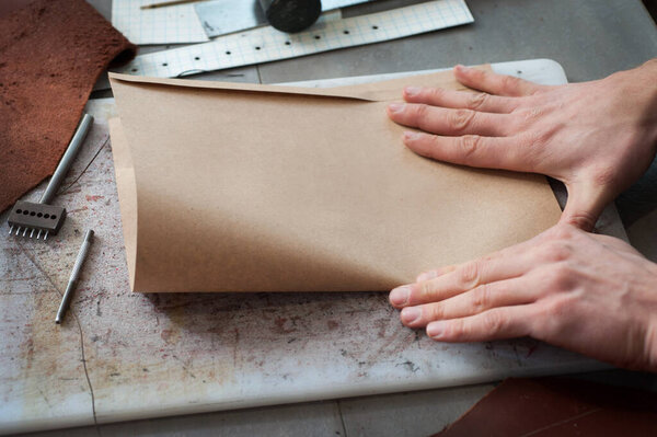 the process of assembling paper kraft bags for packaging handmade leather goods. Small business, manufactories
