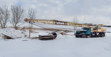 old lifting crane abandoned in winter, frozen construction