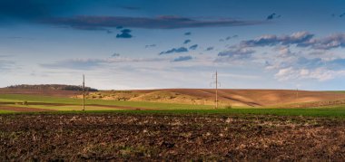 A panoramic view of the arable soil before planting. a plowed field prepared for sowing crops and a hill in the spring.