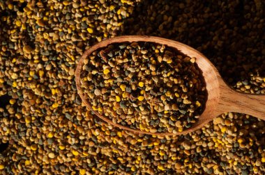 Organik arı poleni ve ahşap kaşık, yakın çekim.