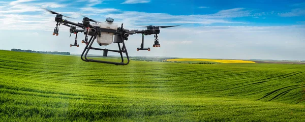 スプレードローンは冬の小麦で畑の丘の上を飛んでいます スマート農業無人機によるZrの適用 収量を増やすためのスポットアプリケーション ストック写真