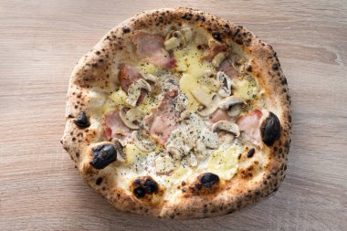 Jambonlu, mantarlı ve peynirli Napoli pizzası. Ahşap ateşinde fırının kenarlarında pişmiş
