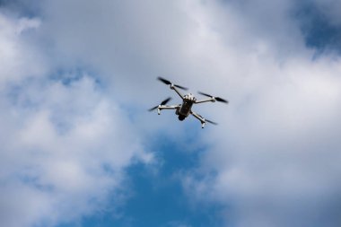 Gökyüzünde bulutlarla uçan dron