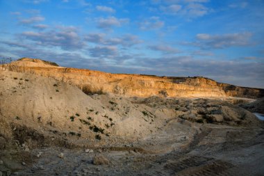 Mavi gökyüzünün arka planında taş ocağının geniş manzarası.