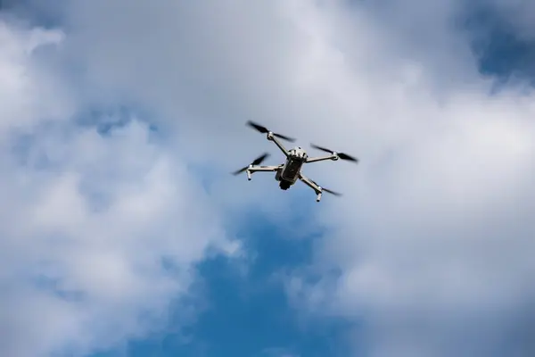 Gökyüzünde bulutlarla uçan dron