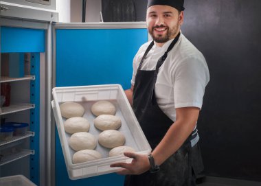 Fırıncı buzdolabında içi boş hamur dolu bir kap tutuyor.