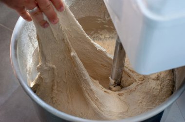 Fırıncı hamuru karıştırma kabında tutarlı hale getirmek için hamur testi yapar.