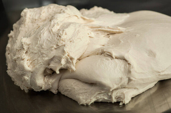 замесное тесто для домашнего хлеба или пиццы, перед разделением на порции