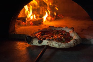 Napoli ahşap fırınında bıçaklı İtalyan pizzası.