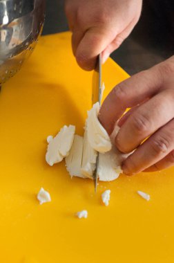 Şef, peynir dilimlerini panoda keser Buffalo mozzarella peyniri parçaları malzemeler için