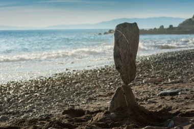 The art of displaying stones in a seemingly weightless or balanced state is called stone balancing. It is a form of land art where stones are arranged on top of each other in intricate arrangements that seem to defy the laws of gravity. clipart