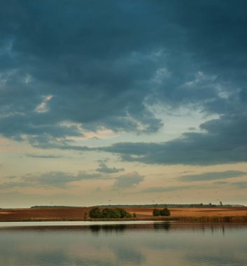 güzel bir göl manzarası ve akşam gökyüzü, karşı kıyıdaki tarlaların manzarası, akşam