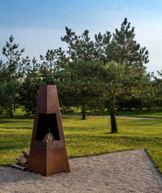 Doğal manzaranın yeşilliğinin, barbekü alanının arka planında geometrik stil metal çerçeveli şömine için bir yer.