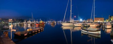 23 Temmuz 2013, Santa Margherita Ligure, İtalya - Limanın gece manzarası, demirli yatlar ve botlar, Ligurian kıyısındaki samimi bir limanda akşam ışıkları ve koyu mavi bir gökyüzü.