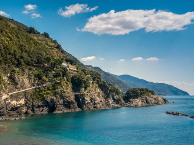 Uçurumlarında kristal berrak su ve yeşil terasları olan Cinque Terre kıyıları. İtalyan uyumu için sakin bir koy..