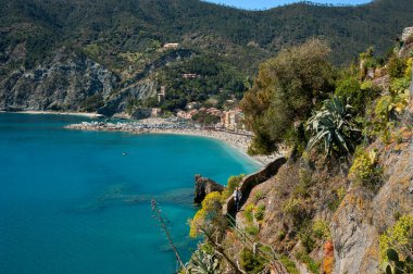 Cinque Terre, Monterosso al Mare adlı deniz kıyısındaki bir köy. Teraslı uçurumlar arasında, turkuaz deniz üzerinde Akdeniz bitkileriyle çevrili taştan bir patika.