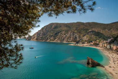 Monterosso al Mare, kristal su, renkli binalar, plaj, yamaçlarda yeşil teraslar, yeşil teraslar olan sessiz bir koy.