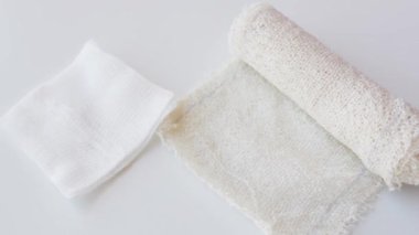 Hastane bandajları ve insan eliyle tutulan boş bir şırınga.