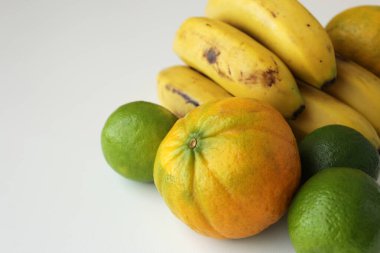 Beyaz arka planda muz, limon ve portakal. Akdeniz diyeti için sağlıklı taze Brezilya tropikal meyveleri. Sürdürülebilir tarım kavramı.