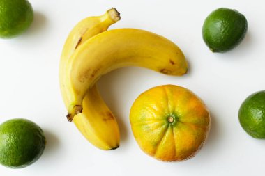 Brezilya 'dan gelen taze organik meyveler beyaz arka planda dizilmiş. Muz, portakal ve limon içeren vegan ve vejetaryen diyeti için sağlıklı malzemeler.
