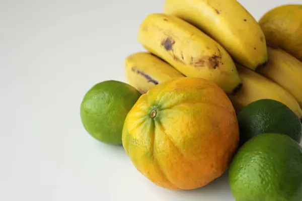 Beyaz arka planda muz, limon ve portakal. Akdeniz diyeti için sağlıklı taze Brezilya tropikal meyveleri. Sürdürülebilir tarım kavramı.