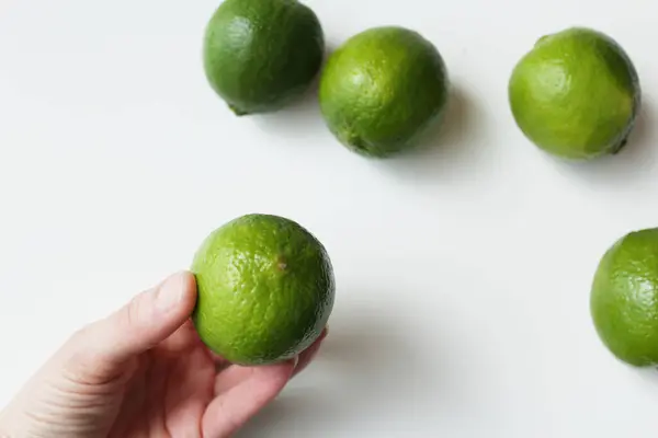 Kafkas eliyle tutulan yeşil tahiti kireci. Sağlıklı beslenme alışkanlıkları için Brezilya tropikal narenciye meyvesi.