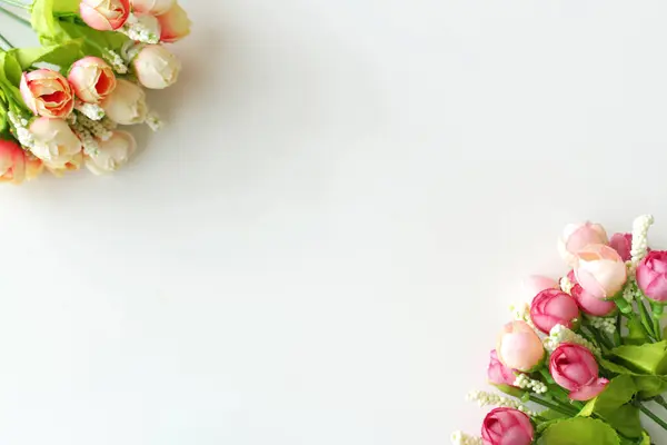 Fotokopi alanı olan düğün davetiyesi arkaplanı. İçinde iki demet yapay gül tomurcuğu var. Bahar zamanı narin çiçek buketi. Sevgililer Günü için tebrik kartı, Anneler Günü ya da Kadınlar Günü.