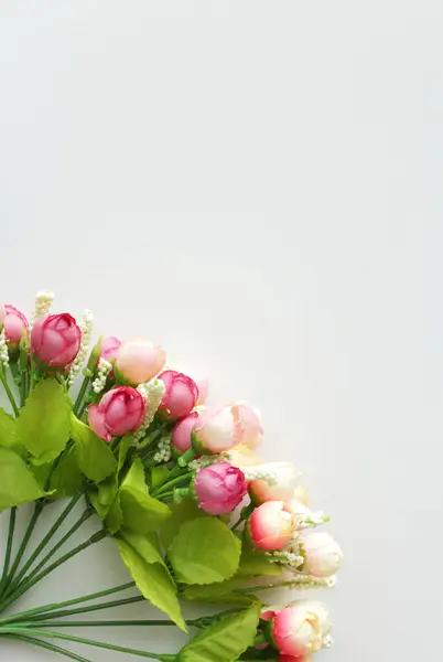 Beyaz dikey arkaplanda gül tomurcukları. Sevgililer günü, kadınlar günü ya da düğün davetiyesi için fotokopi yeri olan yumuşak pembe çiçekler..