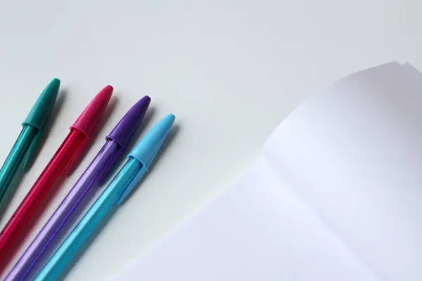 Eğitim afişi için fotokopi alanı olan dört renkli mürekkep kalem ve boş kağıt not defteri. Yaratıcı kırtasiye, sanat dersi, yazı dersi, okula dönüş konsepti..