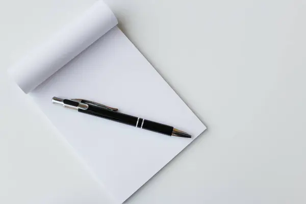 Fotokopi alanı olan siyah kalem ve beyaz not defteri afişi. Ofis malzemeleri, okul kırtasiyesi, eğitim, not alma, yazma konsepti.