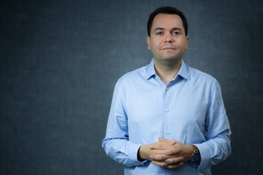 Dost canlısı, birbirine dolanmış parmakları ve ağzı sıkı bir gülümsemesi olan bir iş adamı. Şirket işleri, kariyer geliştirme, ofis işleri ya da İnsan Kaynakları müdürü için mükemmel. Geniş kopya alanına sahip yatay stüdyo portresi.