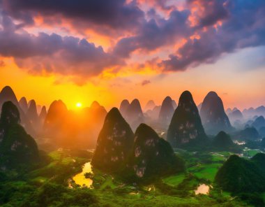 Guilin Hazed Dağı, Çin, Guilin, Piled İpek Dağları üzerinde turuncu sisli gün batımı.